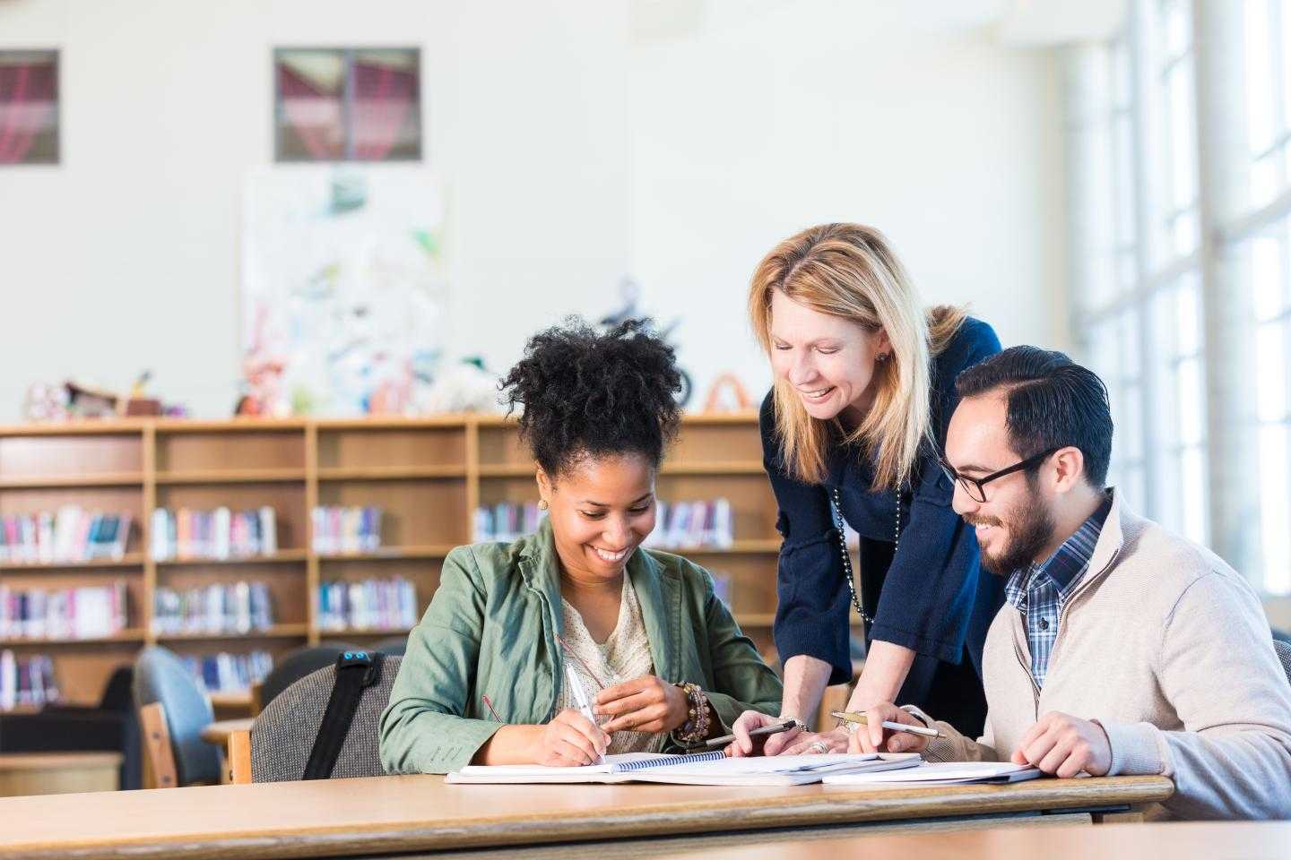 Three adults at a table working together